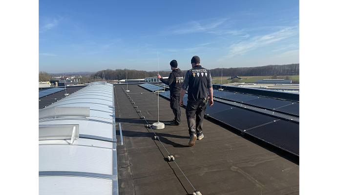 Zwei Techniker auf einem Flachdach mit Solarmodulen