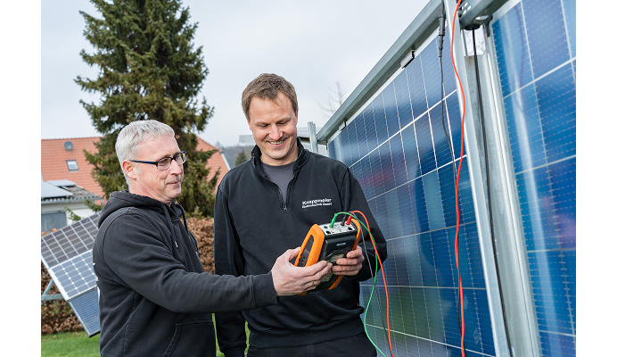 Zwei Techniker bei der Kontrolle einer PV-Anlage