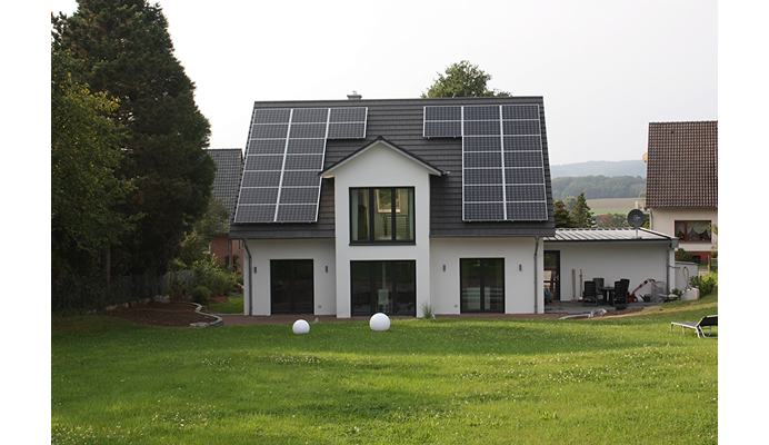 weißes Haus mit PV-Anlage auf dem Dach